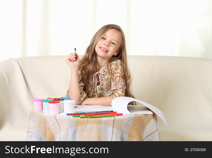 Little Blond Girl Drawing At Home On Sofa