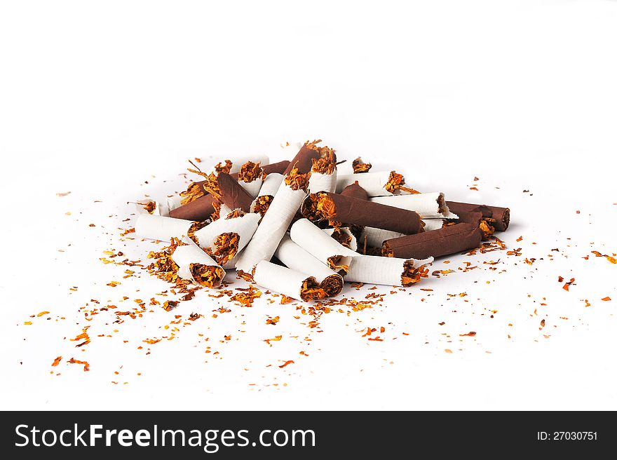 Pile of brown and white broken cigarettes on a white background. Pile of brown and white broken cigarettes on a white background