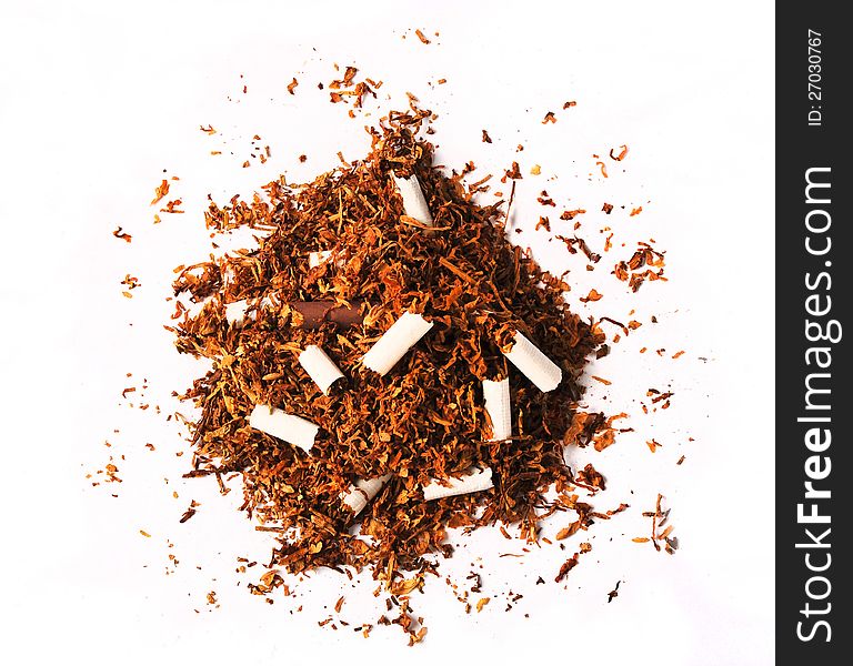 A pile of tobacco leaves with broken cigarettes and no filters isolated on a white background