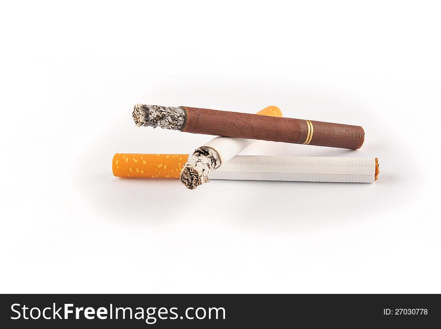 Three cigarettes on a white background. One is brown, the other two are white. Two of them are lit. Three cigarettes on a white background. One is brown, the other two are white. Two of them are lit.