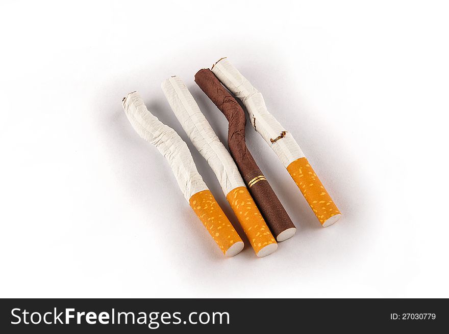 Cigarettes on a white background. Three are bent one is broken. One is white three are white. Cigarettes on a white background. Three are bent one is broken. One is white three are white.