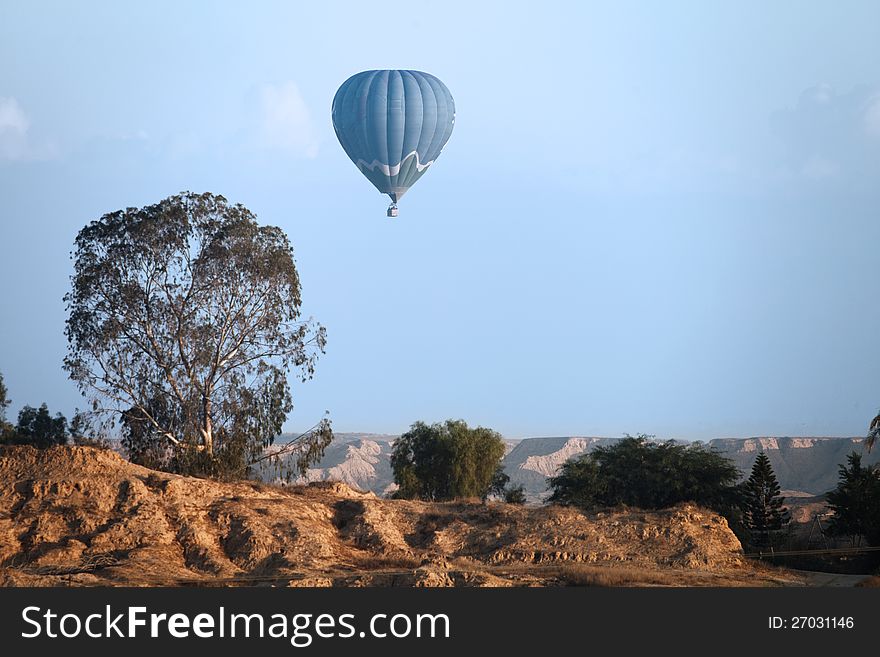 Balloon flying against a rocky landscape