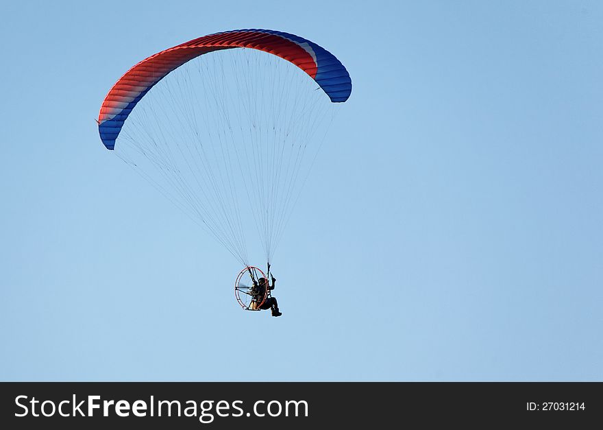 Paratrooper flying in the blue sky