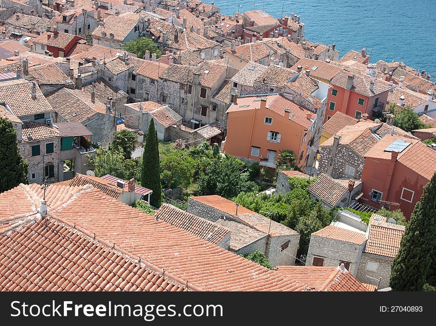 Old mediaeval village streets and red Mediterranean roof in Croatia (Rovinj) with sea and cypress trees in background, seen form bell church of saint Evfemija. Old mediaeval village streets and red Mediterranean roof in Croatia (Rovinj) with sea and cypress trees in background, seen form bell church of saint Evfemija