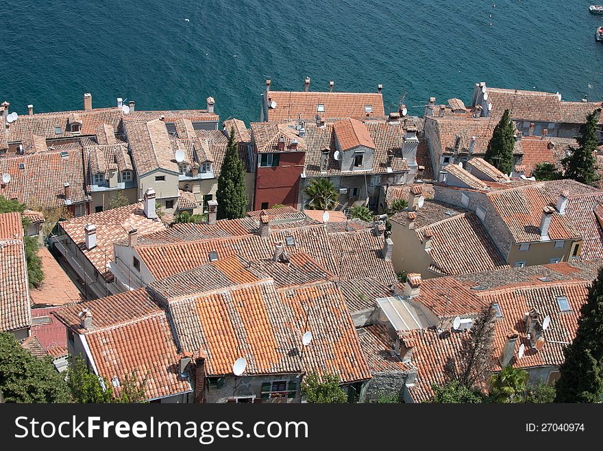 Old mediaeval village streets and red Mediterranean roof in Croatia (Rovinj) with sea and cypress trees in background, seen form bell church of saint Evfemija. Old mediaeval village streets and red Mediterranean roof in Croatia (Rovinj) with sea and cypress trees in background, seen form bell church of saint Evfemija