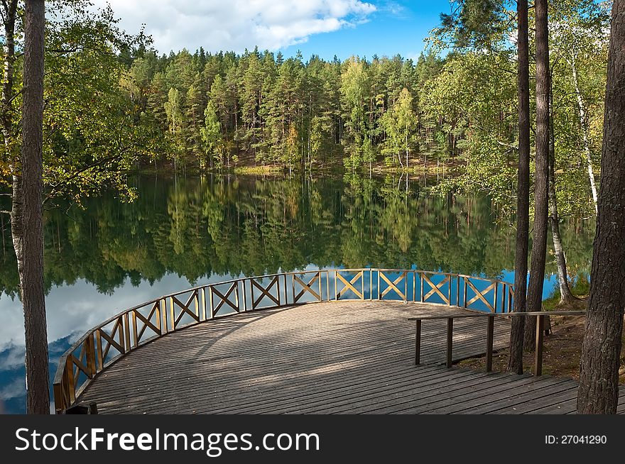 Forest Lake with reflection in the water and the observation deck