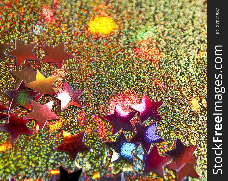 Stars on golden background lit by a colorful christmas lights. Stars on golden background lit by a colorful christmas lights