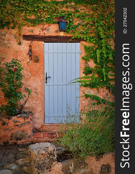 Old blue entrance door in orange wall, Provence, France. Old blue entrance door in orange wall, Provence, France