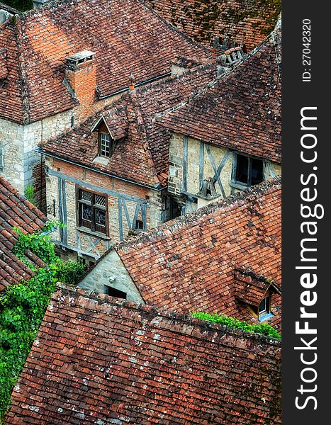 Old village detail of houses with brick roofs and windows, France