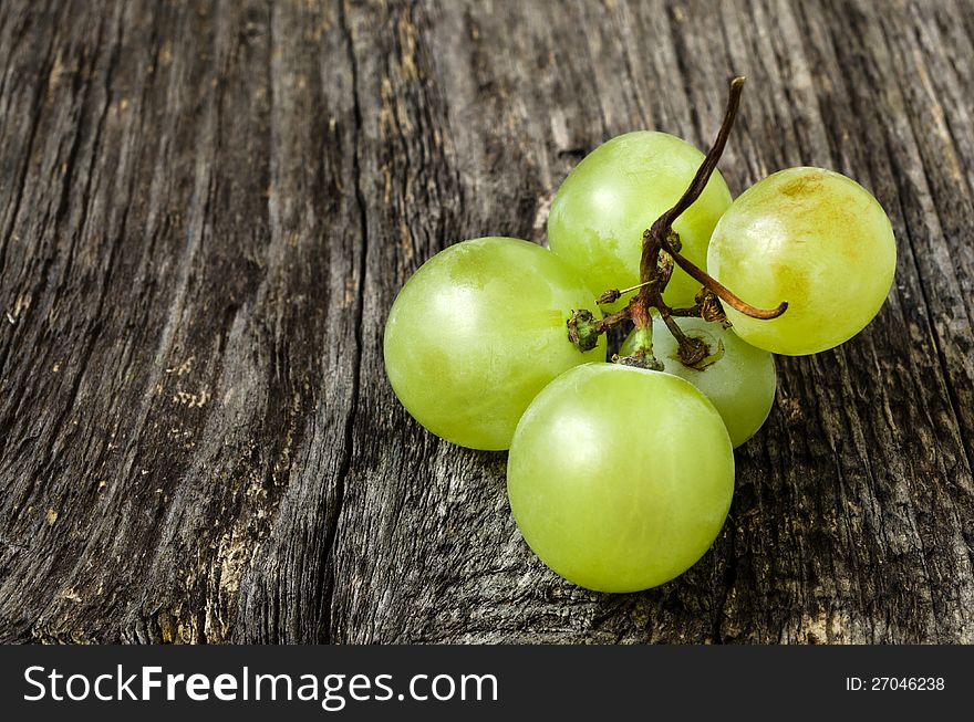 A bunch of green grapes  on wood texture