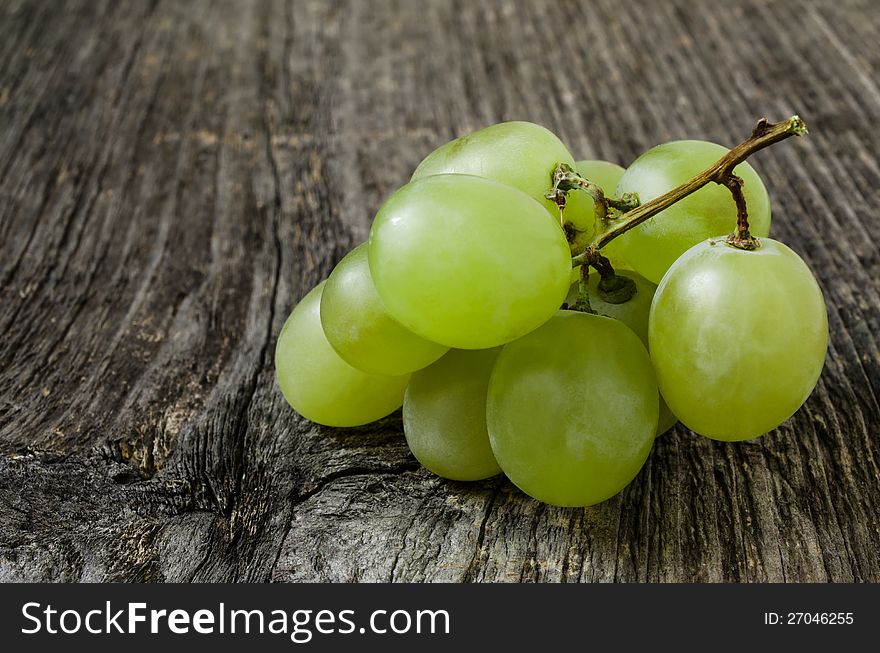 A bunch of green grapes  on wood texture