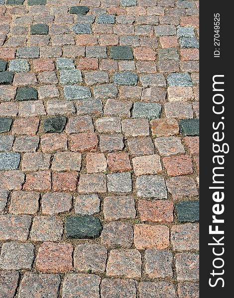 A fragment of the pavement made of granite stone. Background, texture. A fragment of the pavement made of granite stone. Background, texture