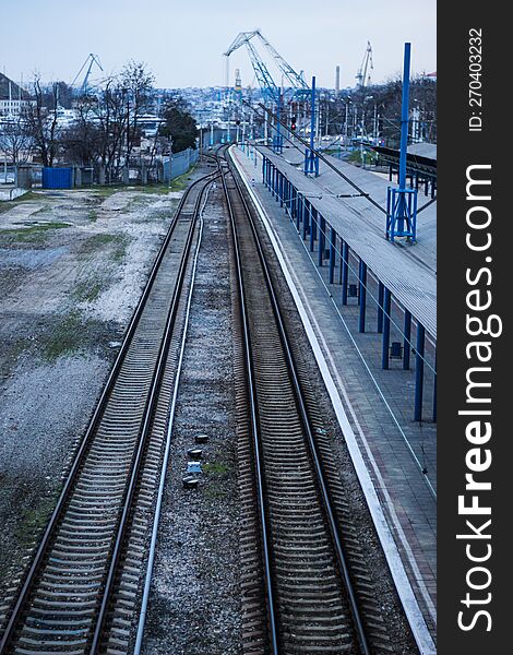 Empty railway station platform. Blue columns at the train station. Top view of the railway.