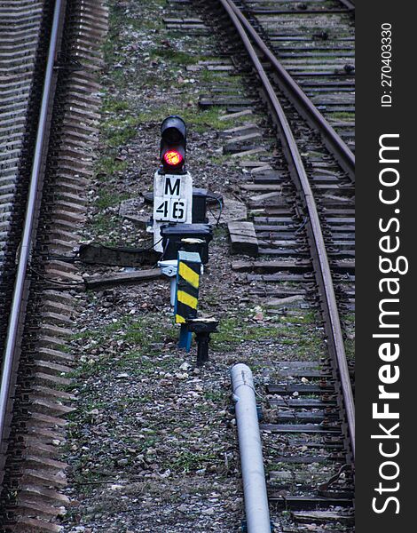 A Small Railway Traffic Light Shows A Red Light. Top View Of An Empty Railway.