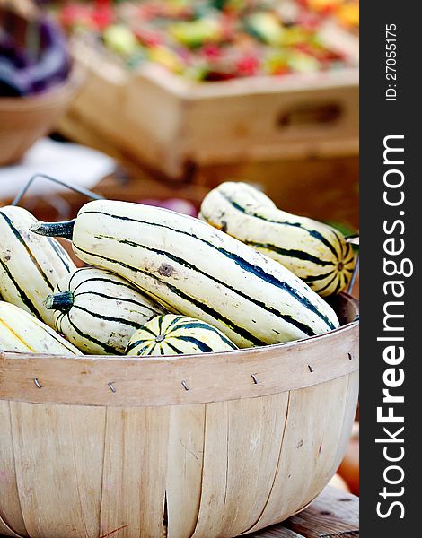 Striped delicata squash in a basket.