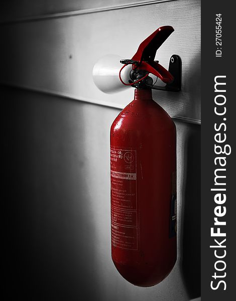 Red extinguisher on gray wall. Red extinguisher on gray wall