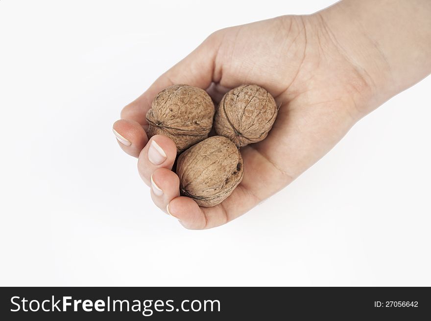 Walnuts and woman hand on the White Background. Walnuts and woman hand on the White Background