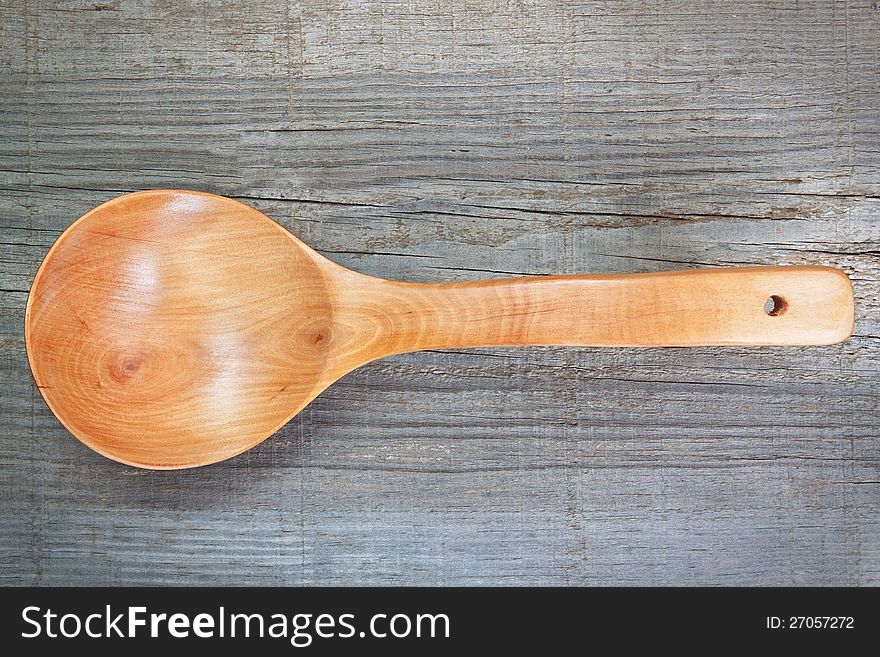 Old wooden spoon on textured board.
