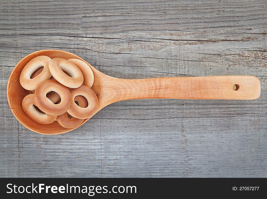 Christmas bagel in a wooden spoon. On textured background.