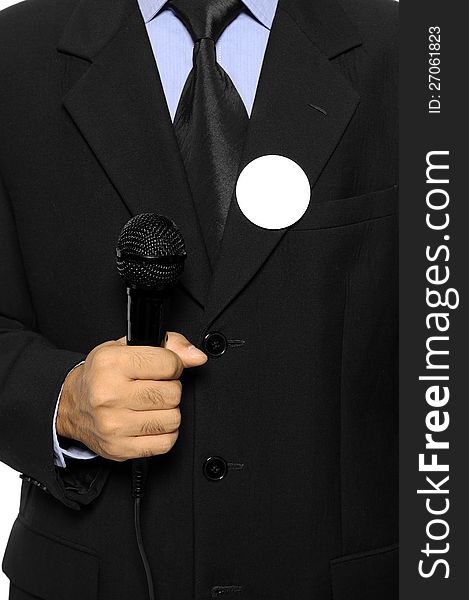 Man with black business suit with blank pinned button hold microphone. You can put your design on the button. Election day background or concept. Man with black business suit with blank pinned button hold microphone. You can put your design on the button. Election day background or concept