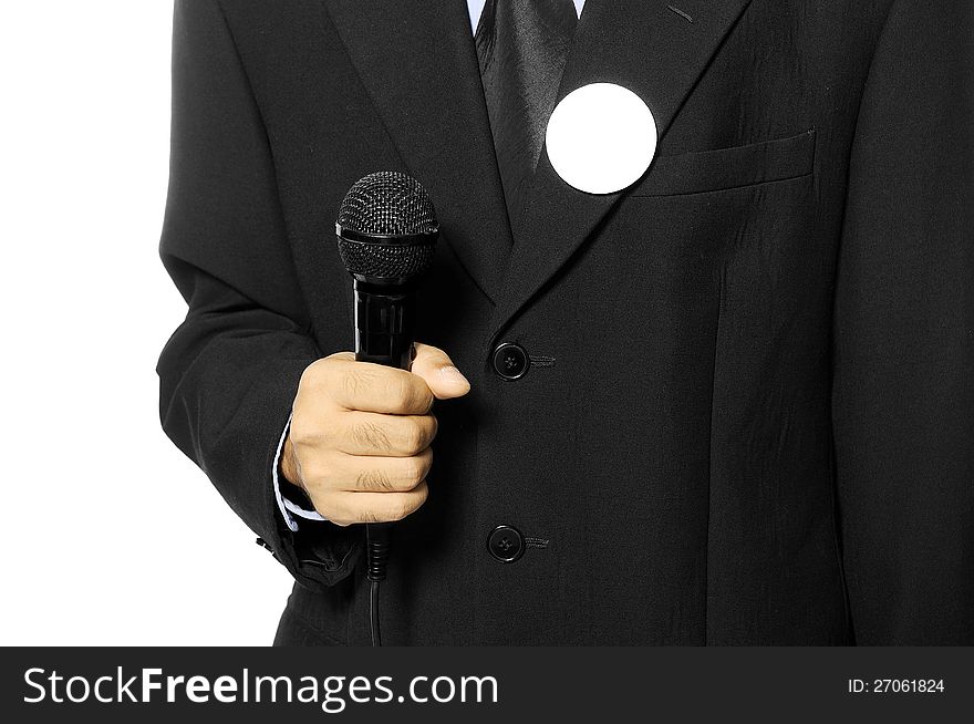 Man with black business suit with blank pinned button hold microphone. You can put your design on the button. Election day background or concept. Man with black business suit with blank pinned button hold microphone. You can put your design on the button. Election day background or concept