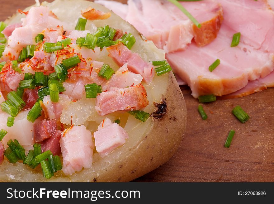 Baked Jacket Potato with Bacon, Paprika, Butter and Spring Onion closeup on wooden background. Baked Jacket Potato with Bacon, Paprika, Butter and Spring Onion closeup on wooden background