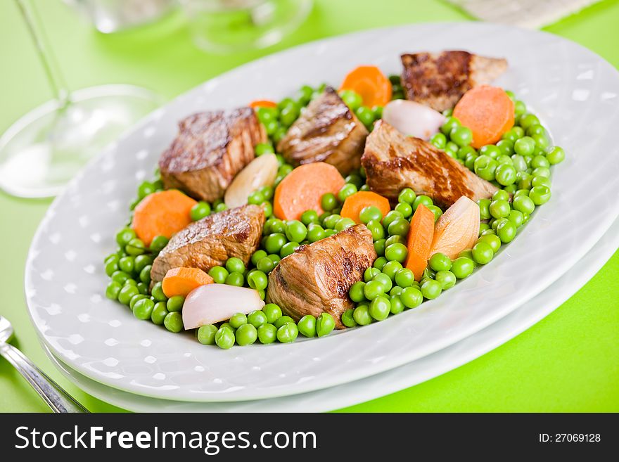 Photograph of a meal of beef with peas and carrots. Photograph of a meal of beef with peas and carrots