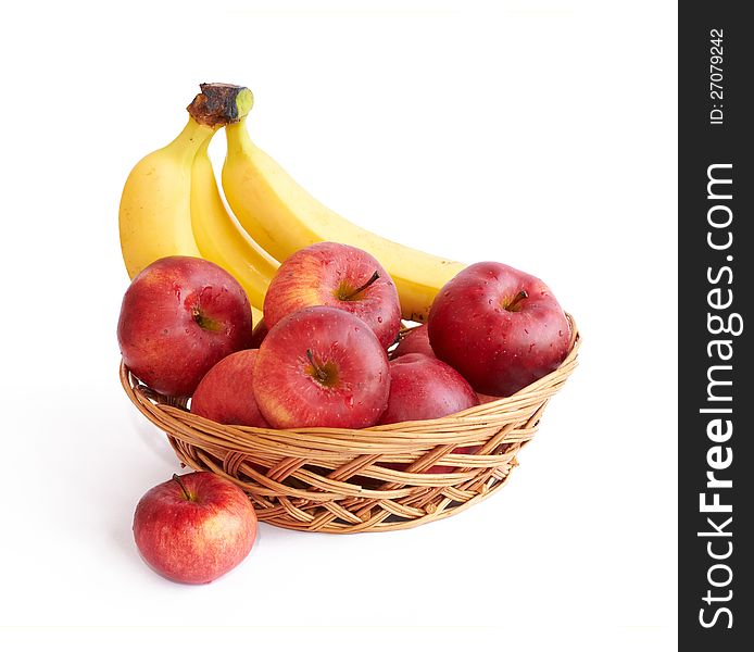 Apples and bananas  in a basket on white background