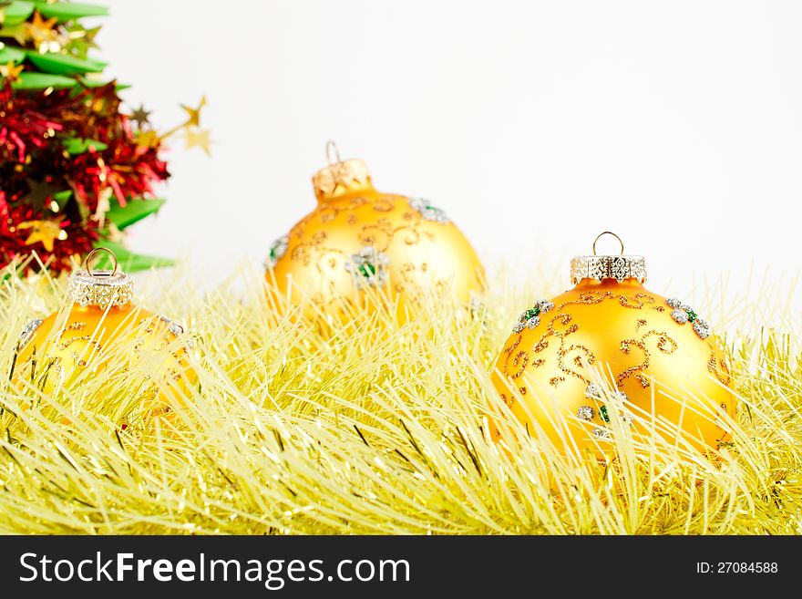 Three Golden Christmas balls on yellow tinsel. Three Golden Christmas balls on yellow tinsel