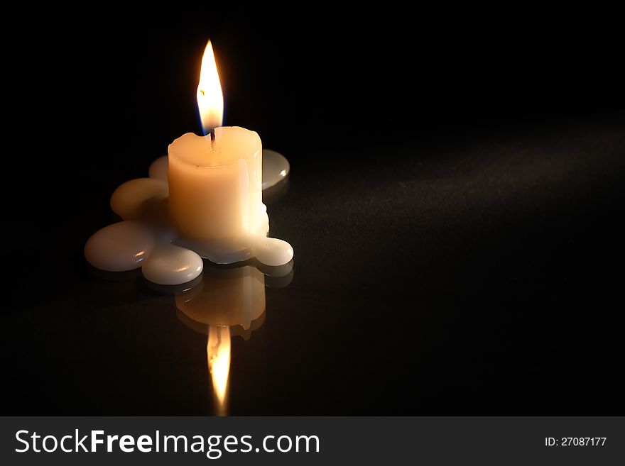 One lighting candle on dark background with free space for text