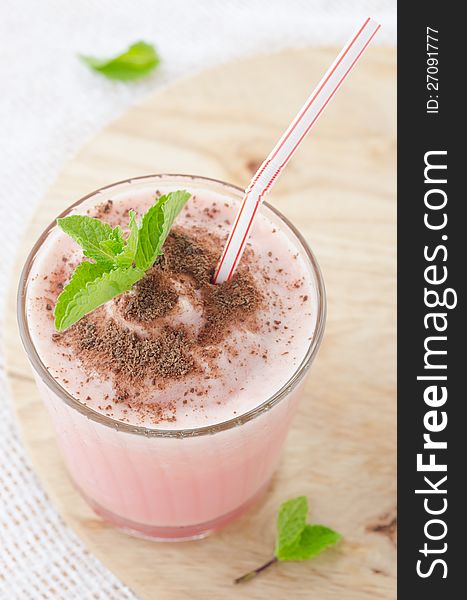 Milk cocktail with watermelon in a glass beaker, decorated with a sprig of mint and chocolate, close-up top. Milk cocktail with watermelon in a glass beaker, decorated with a sprig of mint and chocolate, close-up top