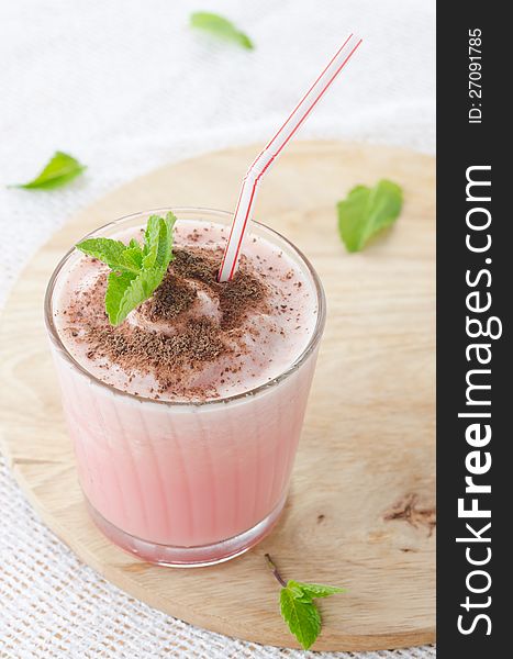 Milk cocktail with watermelon in a glass beaker, decorated with a sprig of mint and chocolate, close-up top. Milk cocktail with watermelon in a glass beaker, decorated with a sprig of mint and chocolate, close-up top