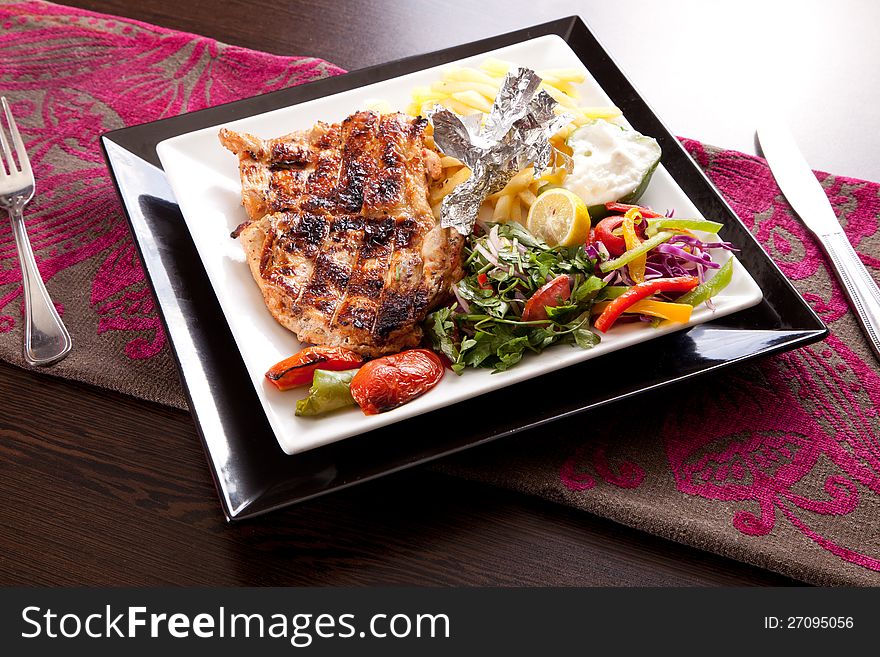 Grilled chicken with chips and vegetables
