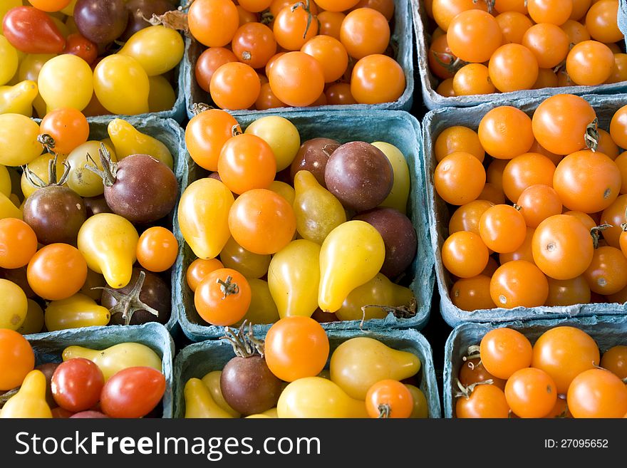 Fresh baby tomatoes of different colors for sale in a farmers market. Fresh baby tomatoes of different colors for sale in a farmers market