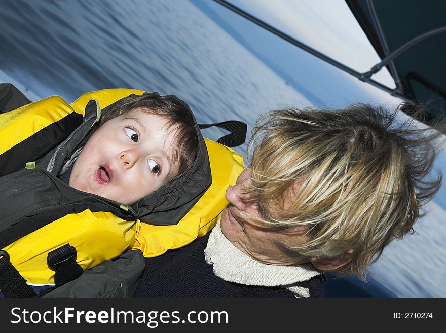 Baby with grandmother on a boat doing faces
