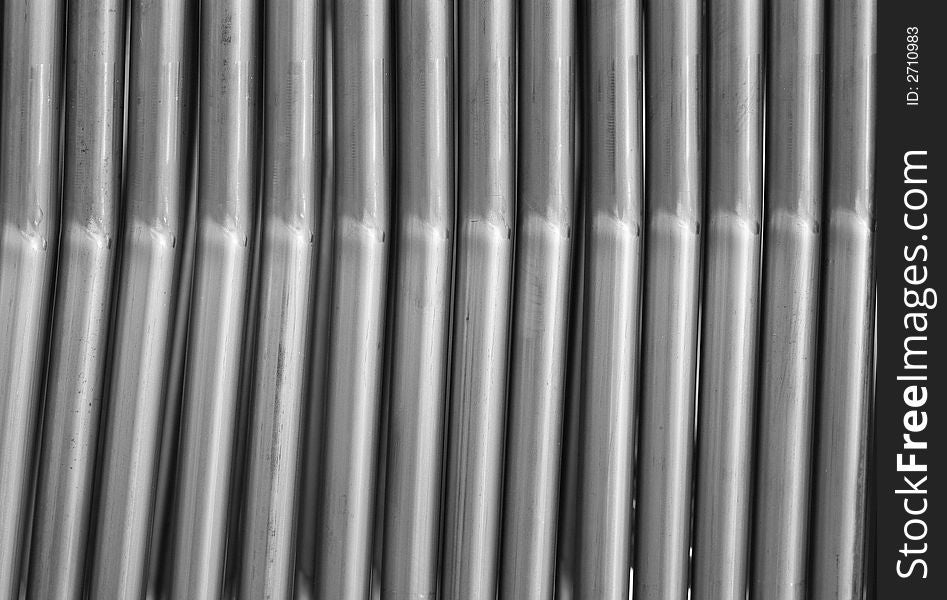Parallel steel tubes, components at a furniture factory. Black and white photo.