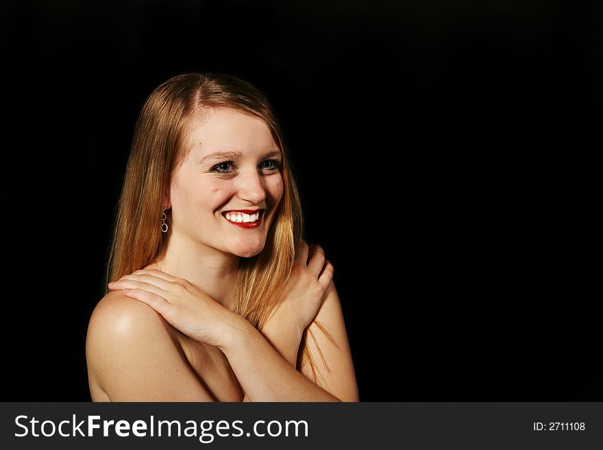 Beautiful blond woman smiling on a black background. Beautiful blond woman smiling on a black background