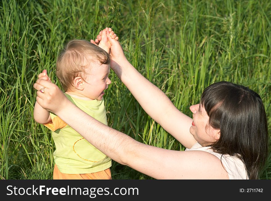 The happy mum and nice child play a nature. The happy mum and nice child play a nature