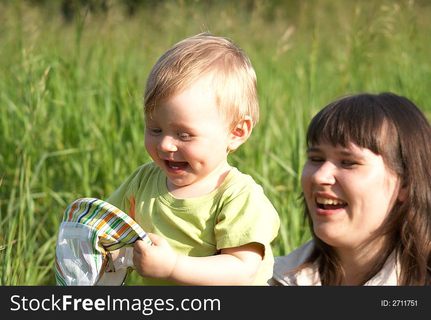 The happy mother plays with the son a background of a nature. The happy mother plays with the son a background of a nature