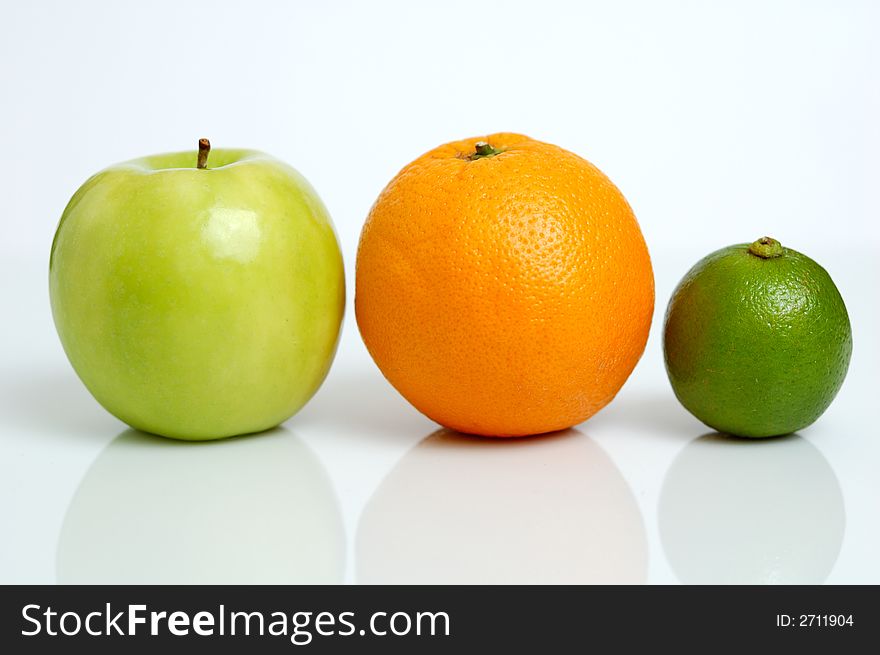 An apple, orange and lime in a row. An apple, orange and lime in a row