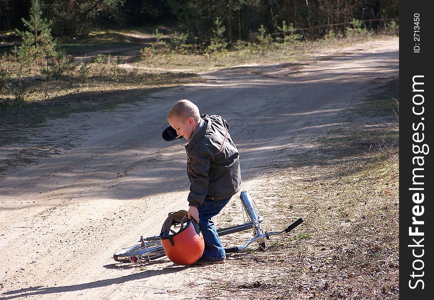 The boy goes for a drive on a bicycle in a fatherly motorcycle helmet. The boy goes for a drive on a bicycle in a fatherly motorcycle helmet