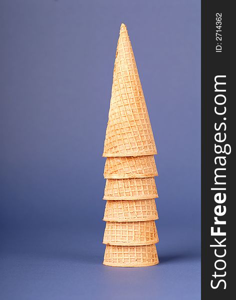 Stack of waffle icre cream cones on blue background. Stack of waffle icre cream cones on blue background