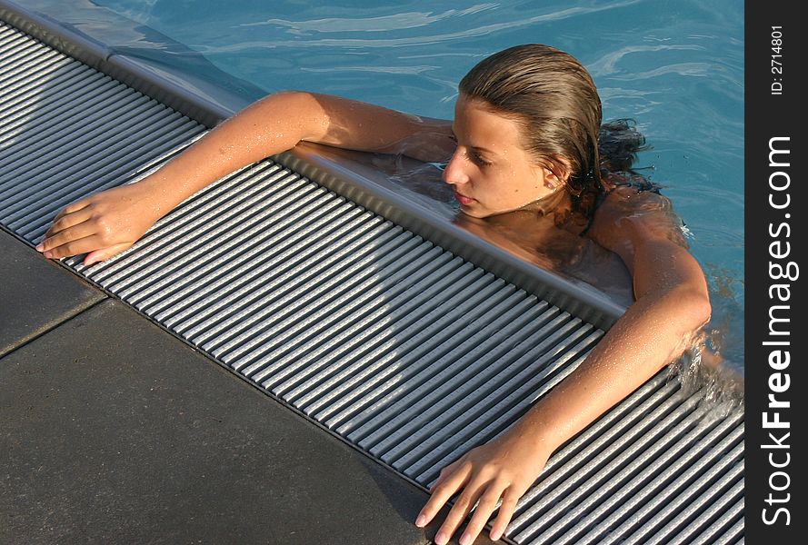 Girl leaning on the outskirts pool. Girl leaning on the outskirts pool