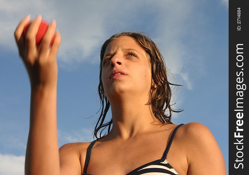 Girl in swimsuit juggling with the red ball. Girl in swimsuit juggling with the red ball
