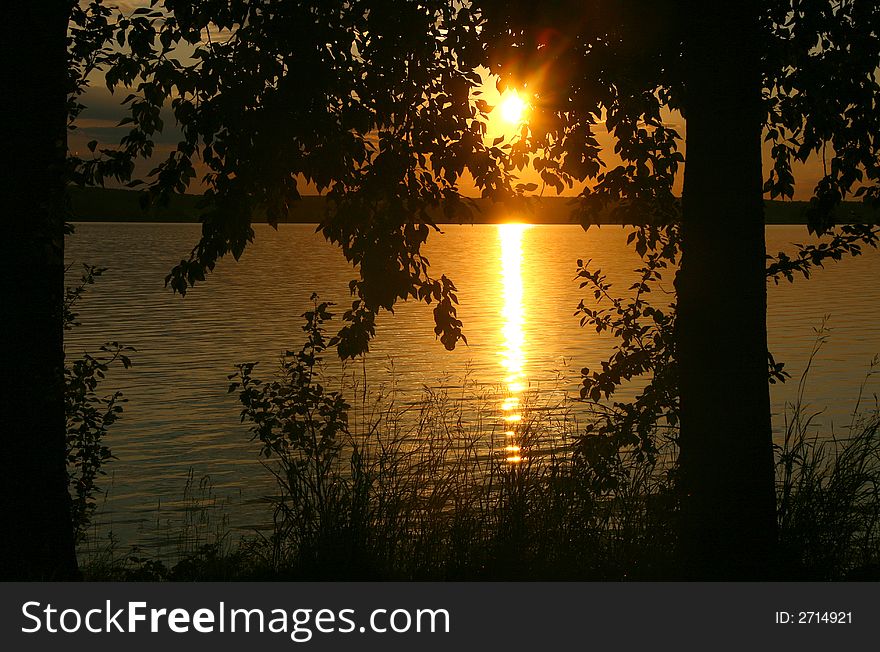 Sunset on coast of lake with trees. Sunset on coast of lake with trees.