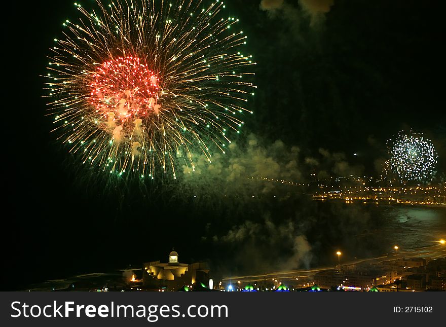 Red and green fireworks over the bay in canary islands