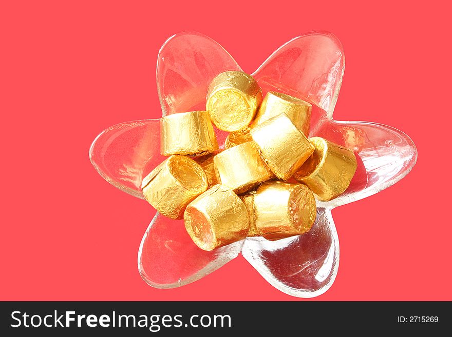 Fancy bowl of chocolates on red background