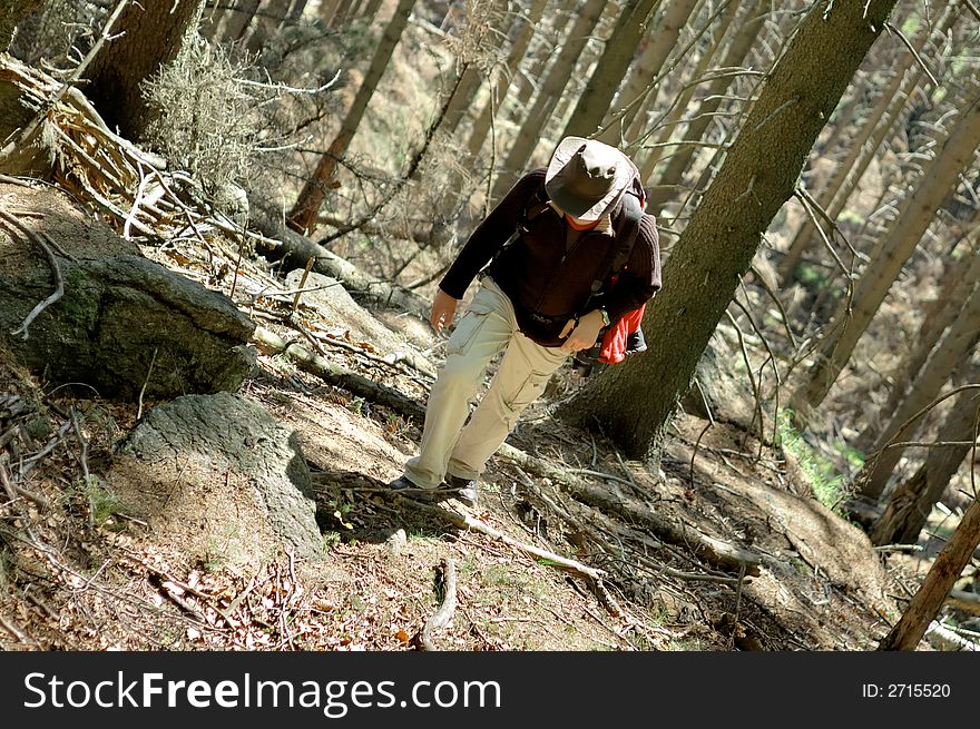 A man slowly moving up hill in the forest. A man slowly moving up hill in the forest