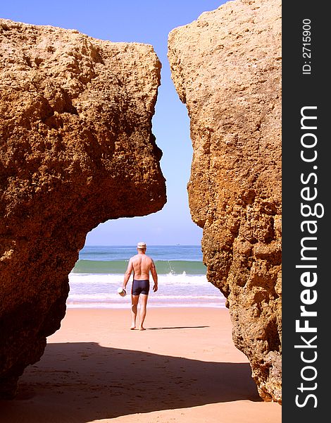 Man walking to the algarve coast into the atlantic ocean. Man walking to the algarve coast into the atlantic ocean