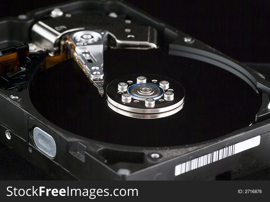 A macro shot of the internal mechanism of a computer hard drive taken against a black backdrop. A macro shot of the internal mechanism of a computer hard drive taken against a black backdrop.